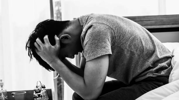 istock Stressed Asian young man sitting alone on bed. Bad relationship or bankrupt problem and sickness concept. 1263110085