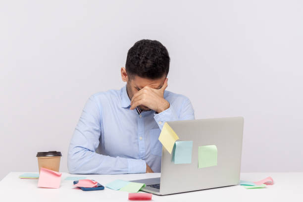 istock Tired unhappy man employee sitting in office workplace with sticky notes all around, bowing head crying, hiding face 1263111089