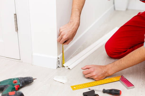 istock Man putting new skirting board in house 1263113246
