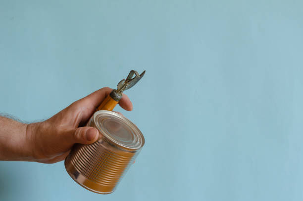 Man's hands hold an old tin can with a wooden handle and a tin can.