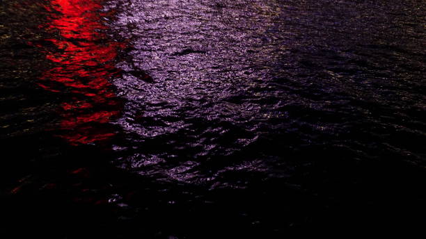 istock Red and White reflection on sea at night, background 1263114411