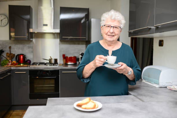 istock happy senior active woman drinking coffee in a modern kitchen at home 1263114484