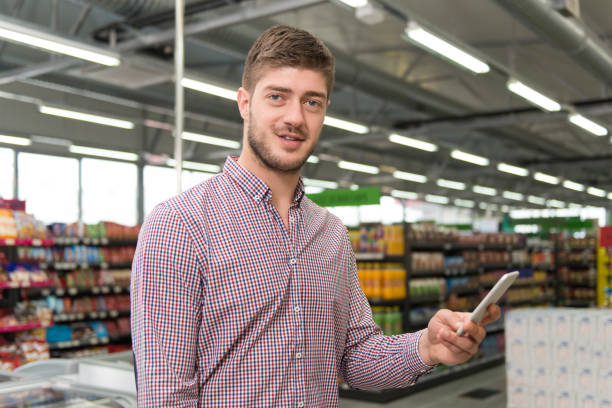 istock Man Using Mobile Phone While Shopping In Supermarket 1263114550
