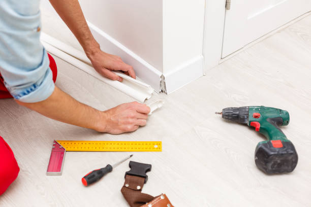 istock Man putting new skirting board in house 1263116872