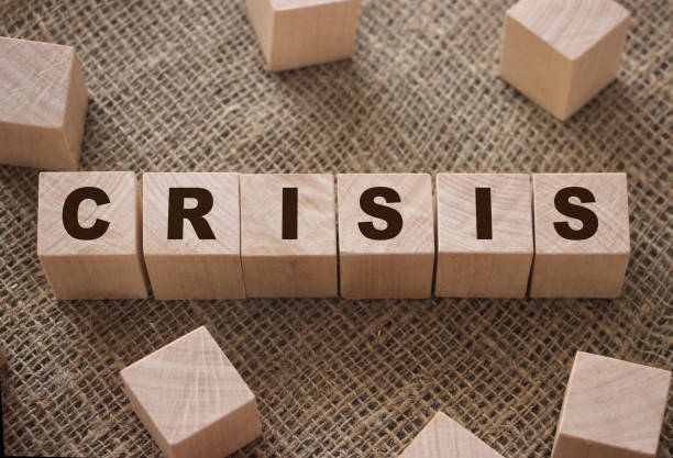 istock Word Crisis on wooden cube blocks on burlap background. Business fall concept 1263118028