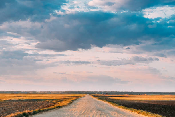 istock Evening Sky Above Rural Landscape With Country Road Through Spring Soil Field Pathway, Way, Open Road In Agricultural Landscape 1263120003