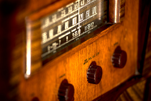 Old, vintage antique floor model stand-up radio 1930s, warm wood tone, dials and push-buttons