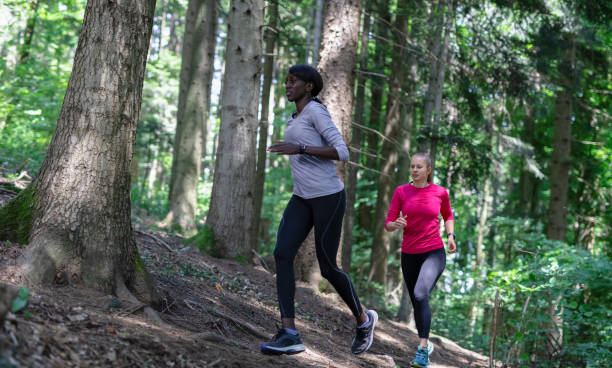 istock Two Young Women Running In A Forest 1263123064