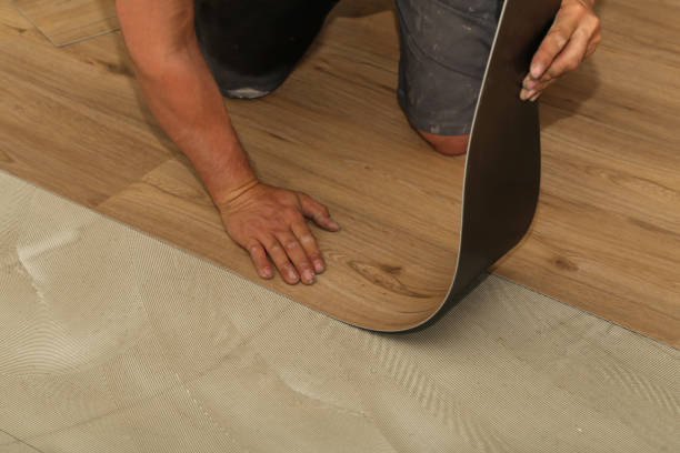 The worker installing new vinyl tile floor stock photo