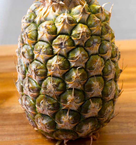 Pineapple isolated on a wooden chopping board, ripe