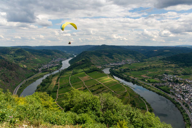 Flying paraglider and colorful countryside