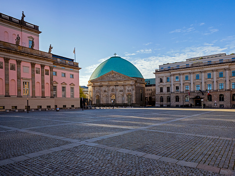 19.04.2020, Berlin, Germany. The Bebelplatz is a square in the Berlin district Mitte. It was built in 1740 as part of the Forum Fridericianum planned by Friedrich II and executed by Georg Wenzeslaus von Knobelsdorff. On the approximately 19,000 m² square, which has been named after the SPD leader August Bebel since 1947, is the Staatsoper Unter den Linden. It is bordered by the magnificent Unter den Linden boulevard to the north, the Princess Palace to the east, St. Hedwig's Cathedral and Behrenstrasse to the south, and the Old Library and Old Palace to the west. Hotel de Rome in the background.