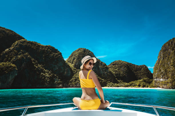 mulher de biquíni asiático viajante relaxa e viaja em barco na maya bay phuket tailândia - maya bay - fotografias e filmes do acervo
