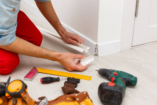 istock Installing the new skirting board after changing the parquet 1263131263