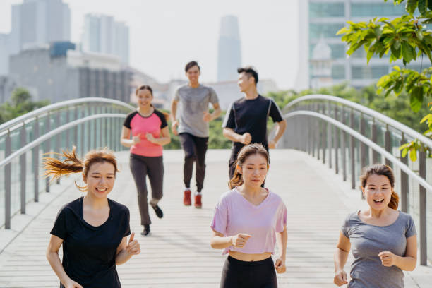 istock Group of young asians jogging through city park 1263132086