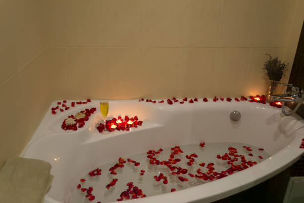 istock Relax in bathroom with aromatic candles and rose petals. SPA time. 1263133192
