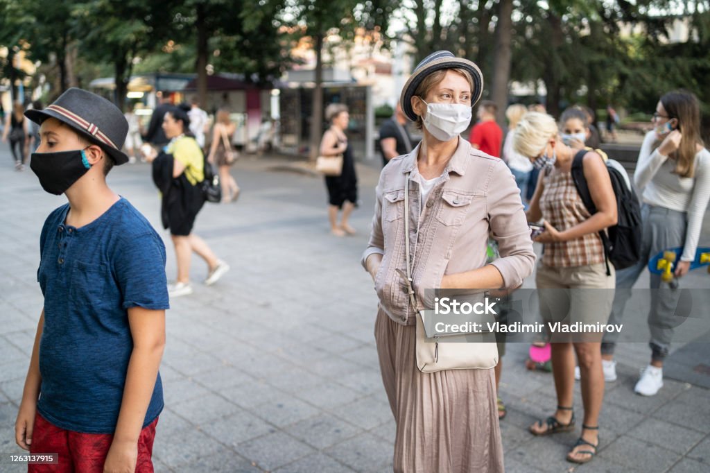 New normal: Social distancing while waiting in line after COVID-19 pandemic Woman wearing face mask, keeping social distancing while waiting in line for fast food in the city centre Protective Face Mask Stock Photo