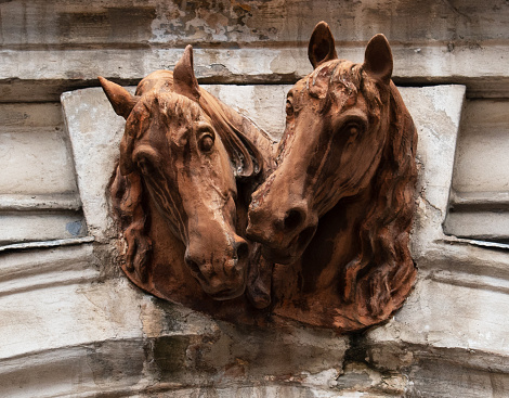 Beautiful decoration of the gate in old palace. Horses heads. Urban motif. Architectural detail, decor