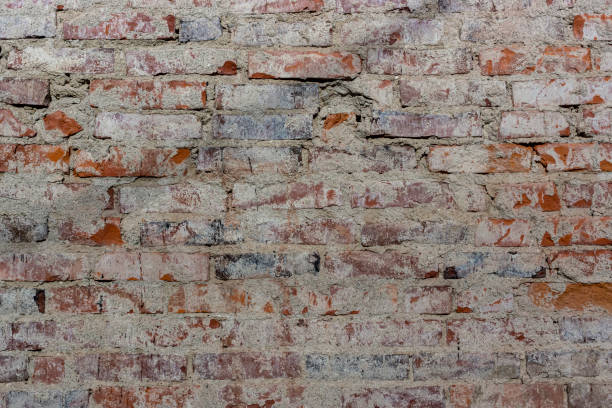 istock Old red bricks of dirty wall background with broken white coating 1263140611