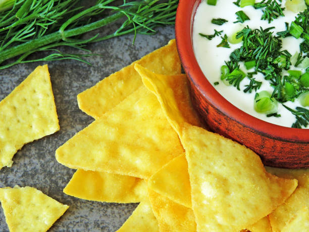 istock Sour cream sauce in a bowl and nachos chips with herbs. 1263140959