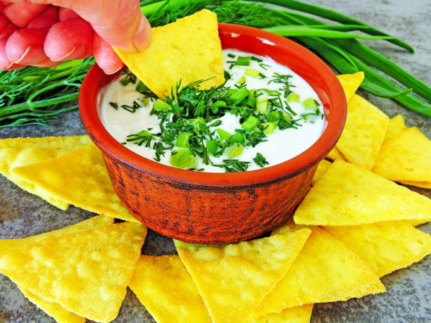 istock Chips nachos with sour cream sauce and greens. 1263140979