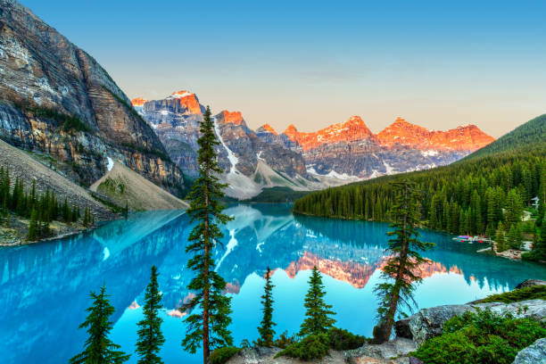 Golden Sunrise Over the Canadian Rockies at Moraine Lake in Canada Golden sunrise over the Valley of the Ten Peaks with glacier-fed turquoise-colored Moraine Lake in the foreground near Lake Louise in the Canadian Rockies of Banff National Park. moraine lake stock pictures, royalty-free photos & images