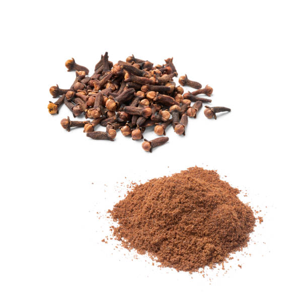 Heap of dried cloves and ground cloves Heap of dried cloves and ground cloves isolated on white background clove spice stock pictures, royalty-free photos & images