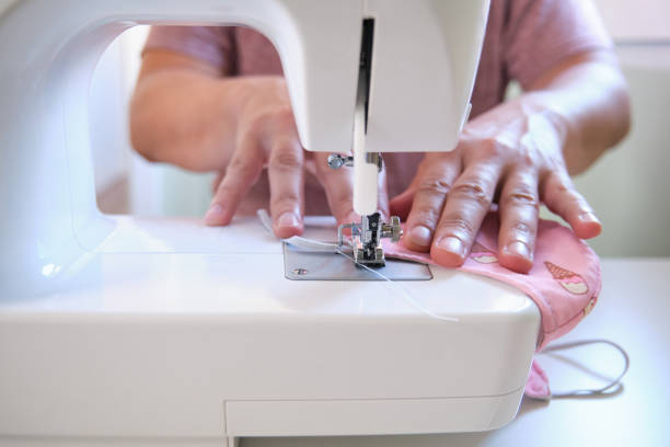 istock Man hands sewing a face medical mask at a sewing machine 1263162150