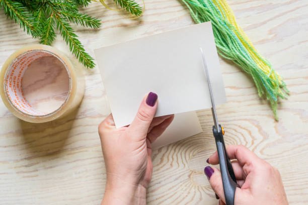 istock DIY Winter craft, small hat. Step 2: Cut paper strips with scissors. 1263168719
