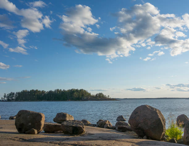 multiple granite stones lying on the granite seashore against the background of the evening sky with sobs