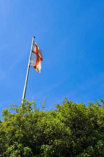 Flag of Freiburg im Breisgau, Germany on a pole on a sunny day.