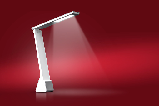 Modern reading lamp isolated on red background with clipping path.