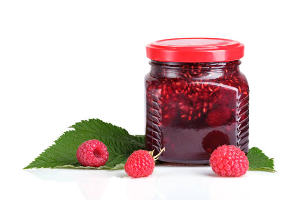 istock Raspberry jam in a jar and fresh raspberries isolated on white background 1263178574