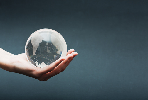 Female hands cradle a crystal globe.