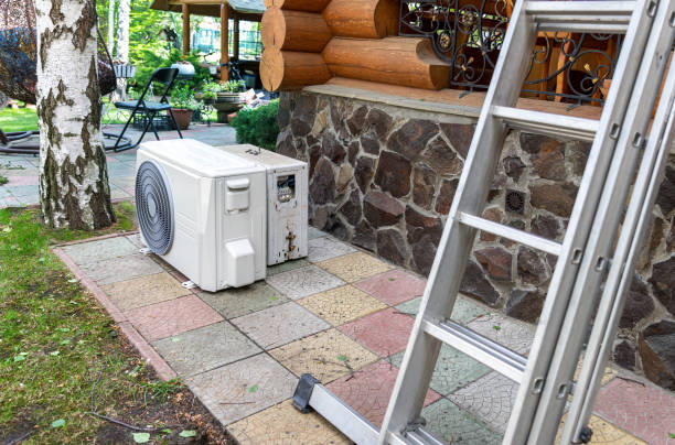 istock New modern HVAC air conditioning external compressor unit preapred for installation or replacement near wall of wooden log residential country cottage. Ladder and equipment for service and maintenance 1263213249