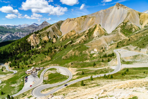 the scenic serpentine road climbing up to the col d'izoard (2360), one of the most famous mountain passes of the tour de france - 2360 imagens e fotografias de stock