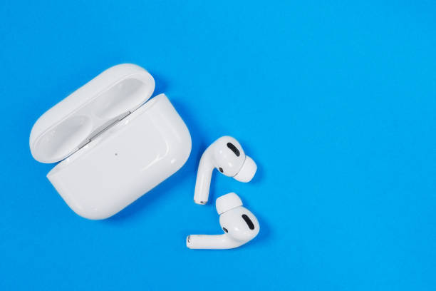 drahtlose kopfhörer apple airpods pro in geöffneten ladetasche mit aktiver geräuschunterdrückung immersiven sound, auf blauem hintergrund, kopierraum. - apple computers audio stock-fotos und bilder