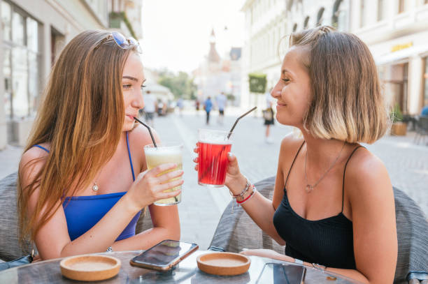 istock Two female friends laughing, drinking lemonade and having fun in a restaurant 1263229061