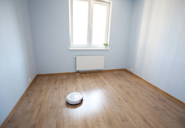 istock White robotic vacuum cleaner on laminate floor cleaning dust in empty room interior 1263229177