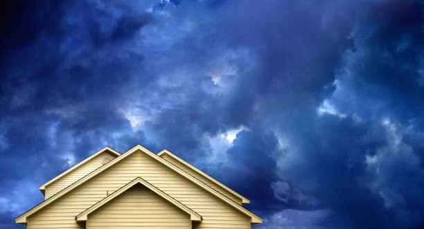 close up rooftop of a wooden house over dramatic sky with storm clouds.