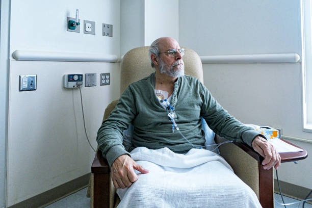 senior adult man cancer outpatient during chemotherapy iv infusion - paciencia fotografías e imágenes de stock