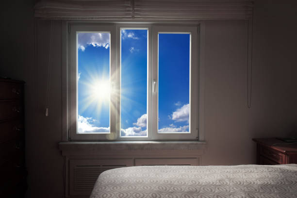 indoor view of close up empty bedroom window over sunny blue sky