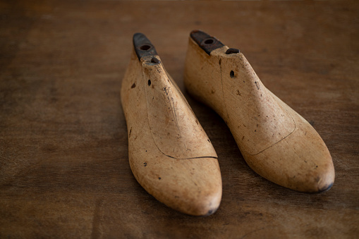 vintage boots with laces on wooden soles isolated on white background. top view