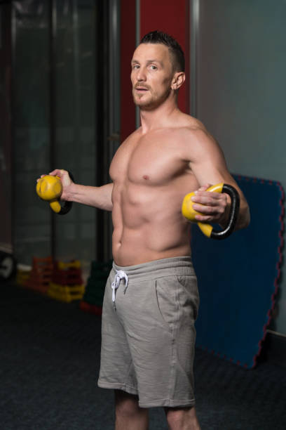 joven haciendo ejercicio con kettle bell - kettle bell activity aerobics athlete fotografías e imágenes de stock