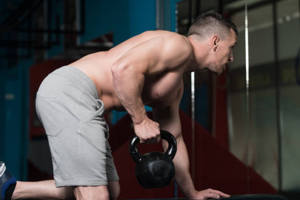 muskularny człowiek ćwiczenia z czajnik-dzwon - kettle bell activity aerobics athlete zdjęcia i obrazy z banku zdjęć