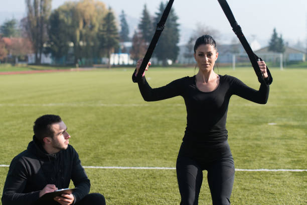 istock Young Couple Exercising Trx Straps in Park 1263252669