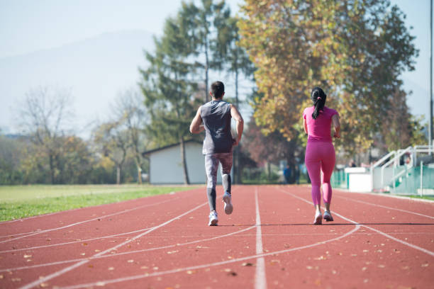 istock Athletic Couple Sprinting on the Running Track 1263252691