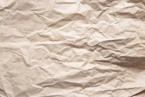 Photo of Crumpled old brown yellow paper. Rough old texture. Abstract background with space for text. Aging concept