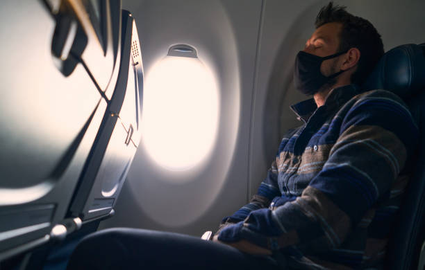 istock Tired man with protection face mask sleeping in an empty airplane during coronavirus pandemic 1263259280