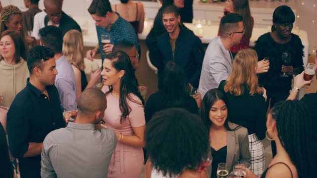 4k video footage of a group of young people having drinks and socialising at a party